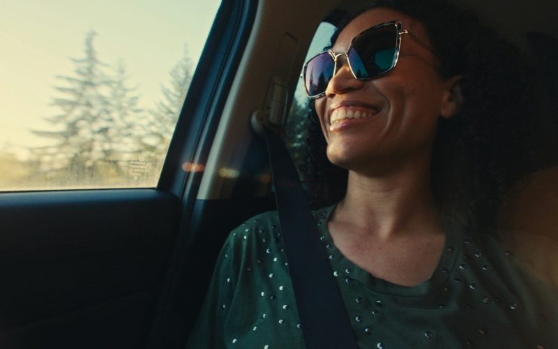 Happy woman smiling and enjoying a car ride.