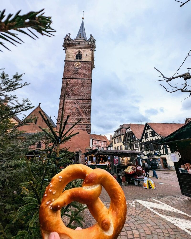Giant pretzel in front of historic european town square.